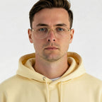 Homem usando óculos de grau com armação dourada e hoodie amarelo, estilo moderno e casual