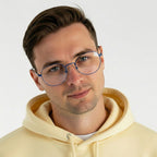 Homem usando óculos de armação azul e moletom amarelo