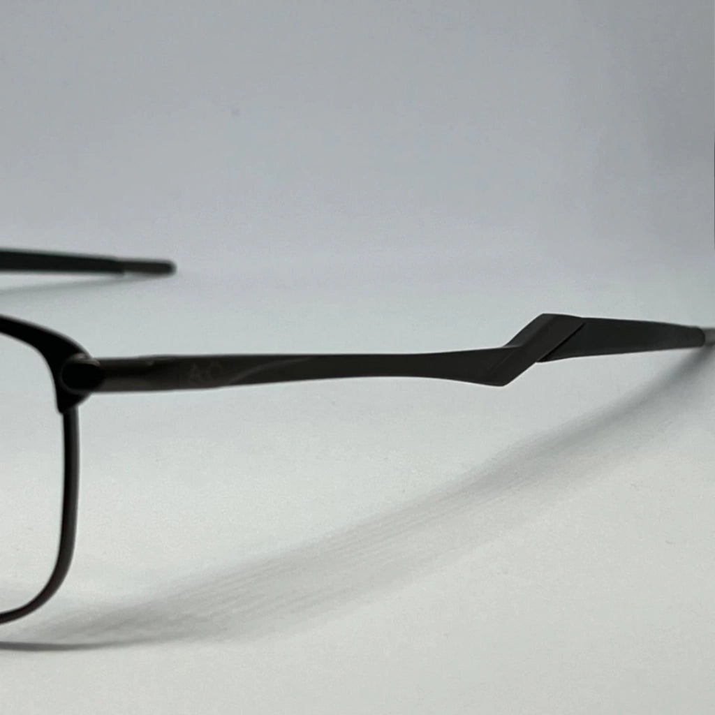 Armação de óculos preta com design moderno e hastes angulares, ideal para ótica e estilo urbano.