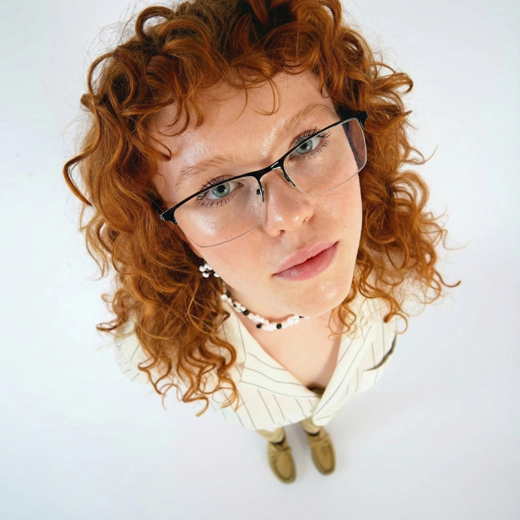 Mulher com óculos de grau modernos e cabelo cacheado ruivo, estilo casual