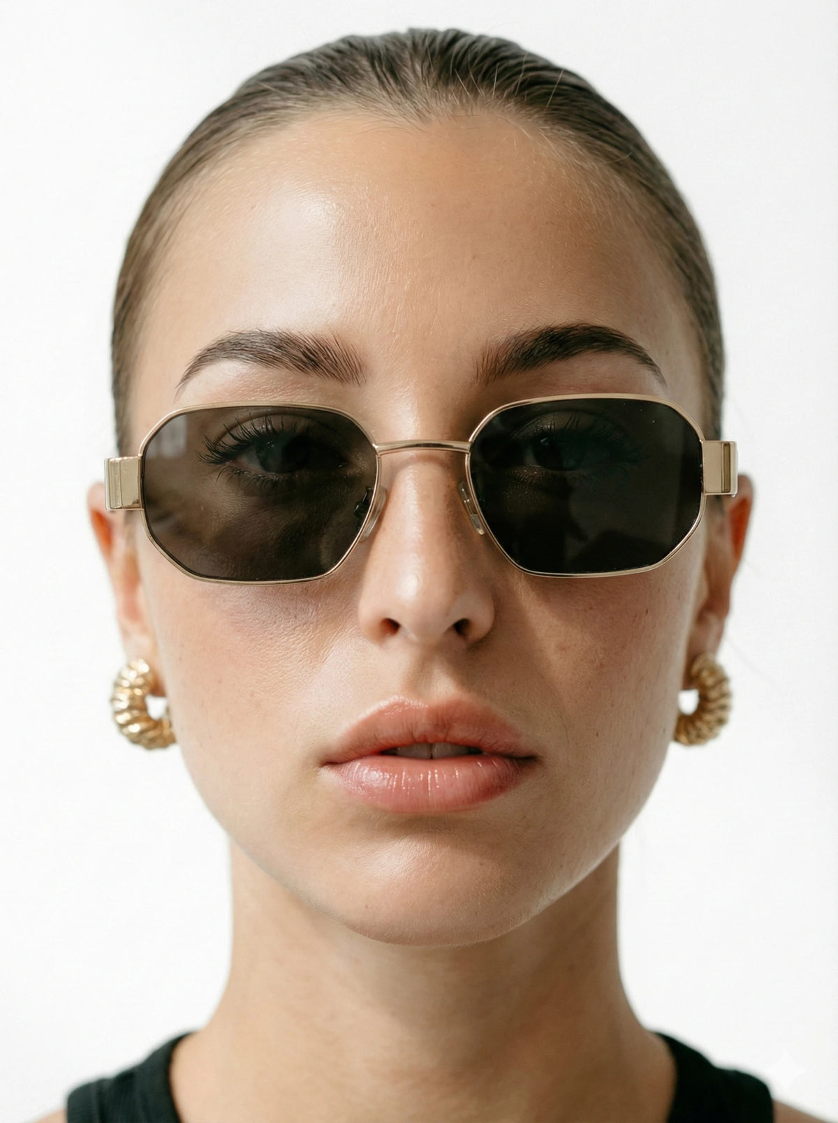 Mulher de coque com óculos de sol de metal dourado